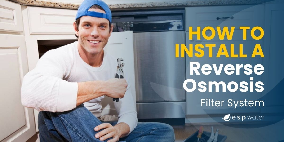 Man installing a reverse osmosis filter system under a kitchen sink.