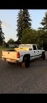 Rear three-quarter sunset view of white Silverado 2500HD thumbnail