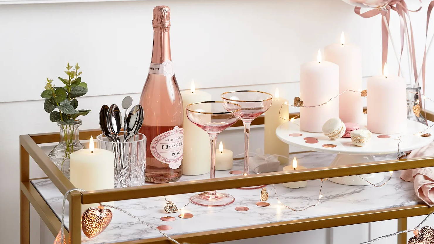 Valentines day table with LED candles, micro heart lights displayed with prosecco and glasses sat on table 