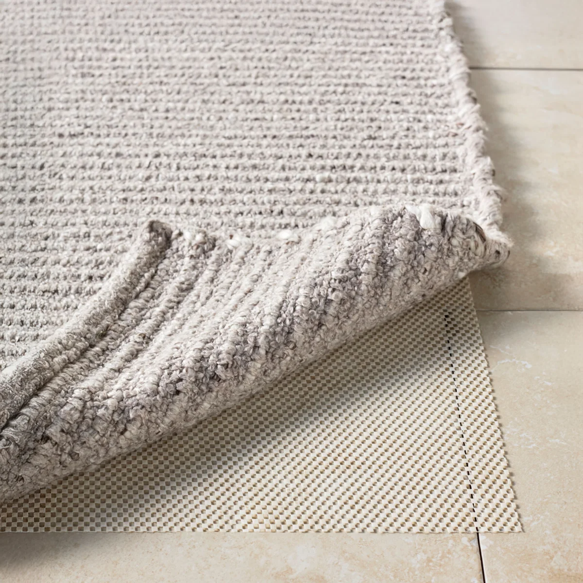 Thick textured area rug paired with a non-slip rug pad, demonstrating how rug pads improve stability and comfort on outdoor patio surfaces. 