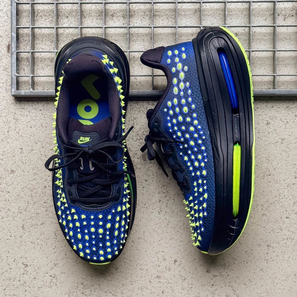 A pair of blue and neon athletic shoes on a surface.