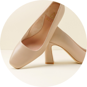 A pair of beige high-heeled shoes positioned on a light background.