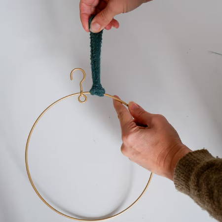 last step of tying a knot around the wreath base