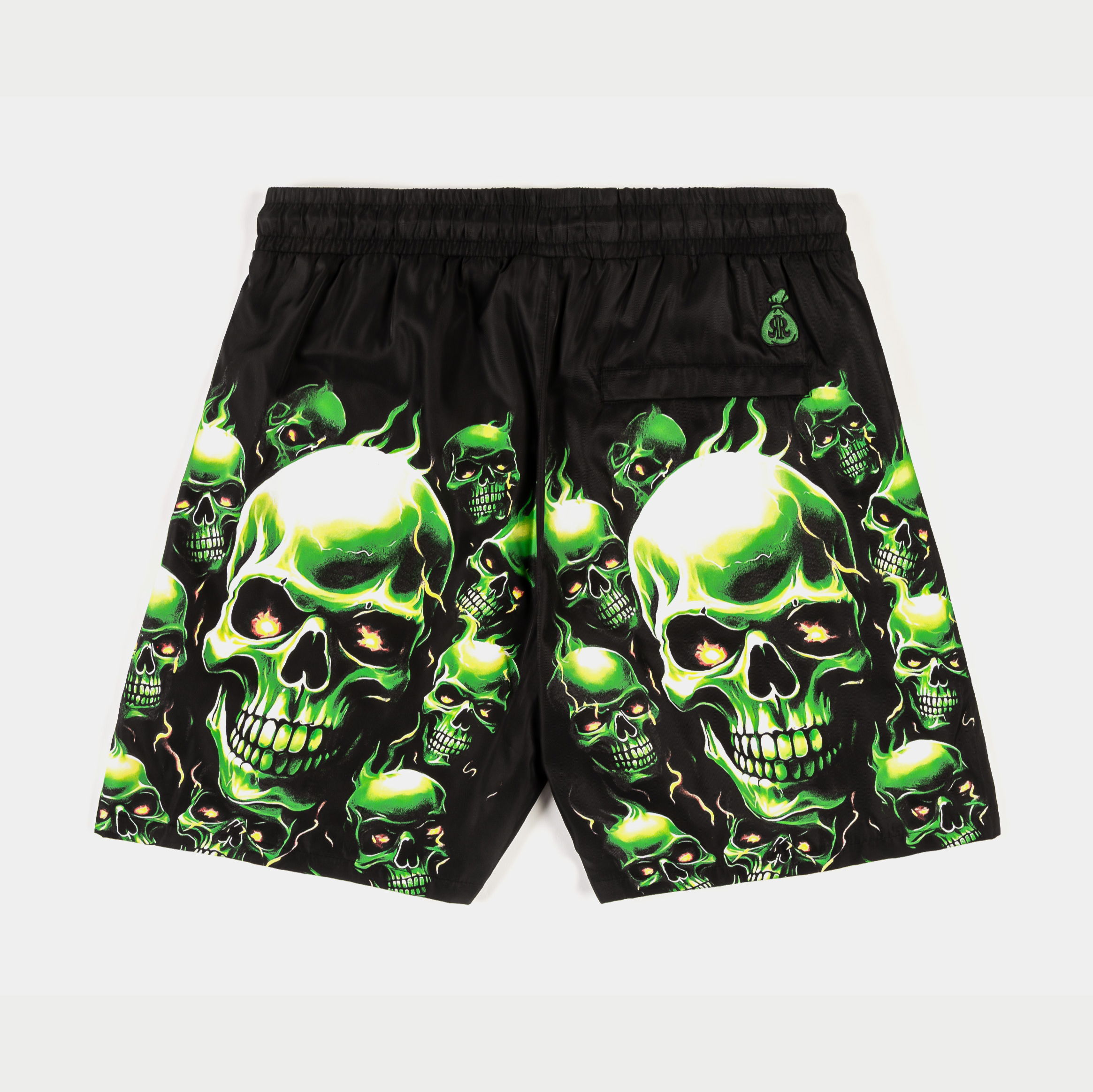 Black swim trunks with green skull designs and drawstring.