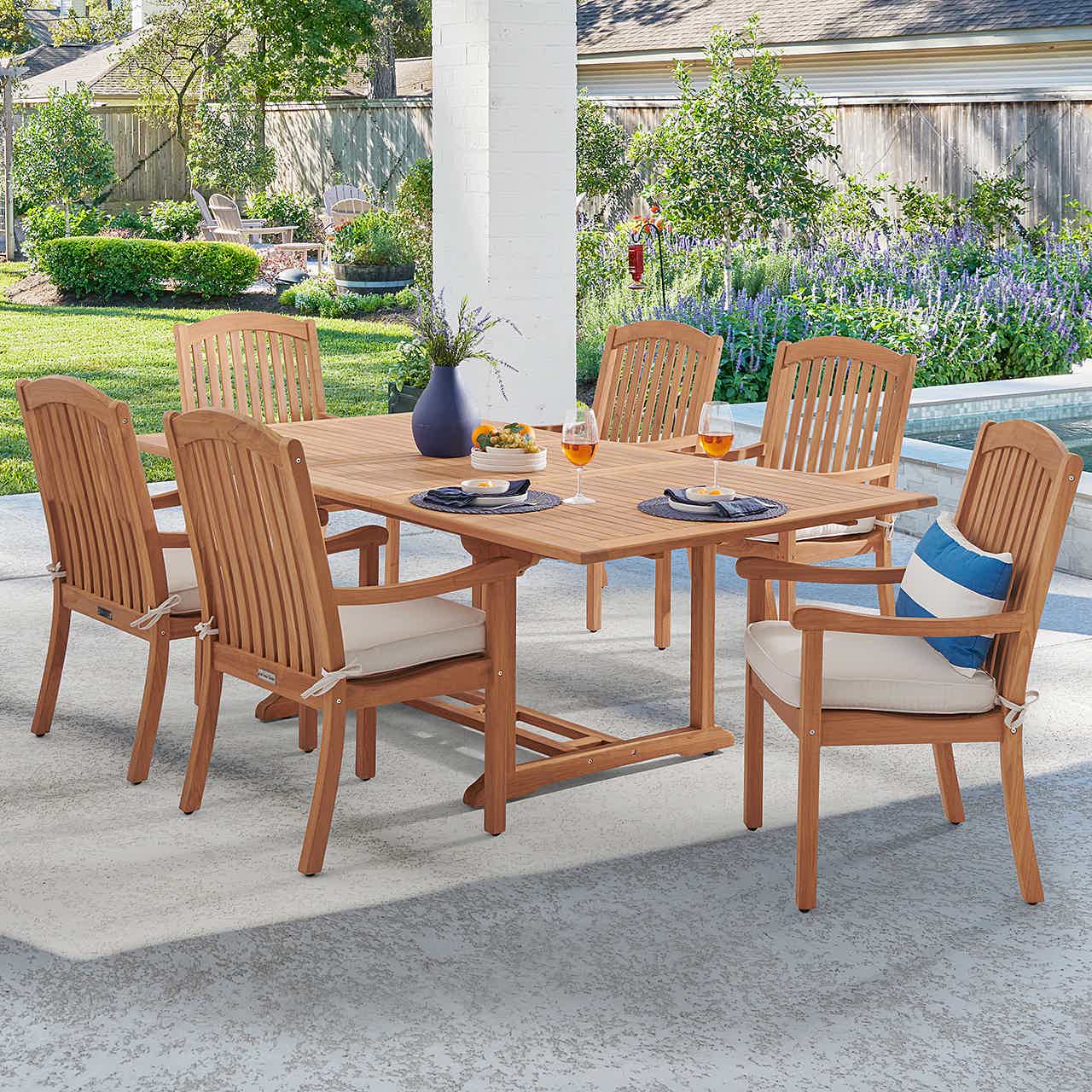 Outdoor dining table set with six chairs and decorative items.
