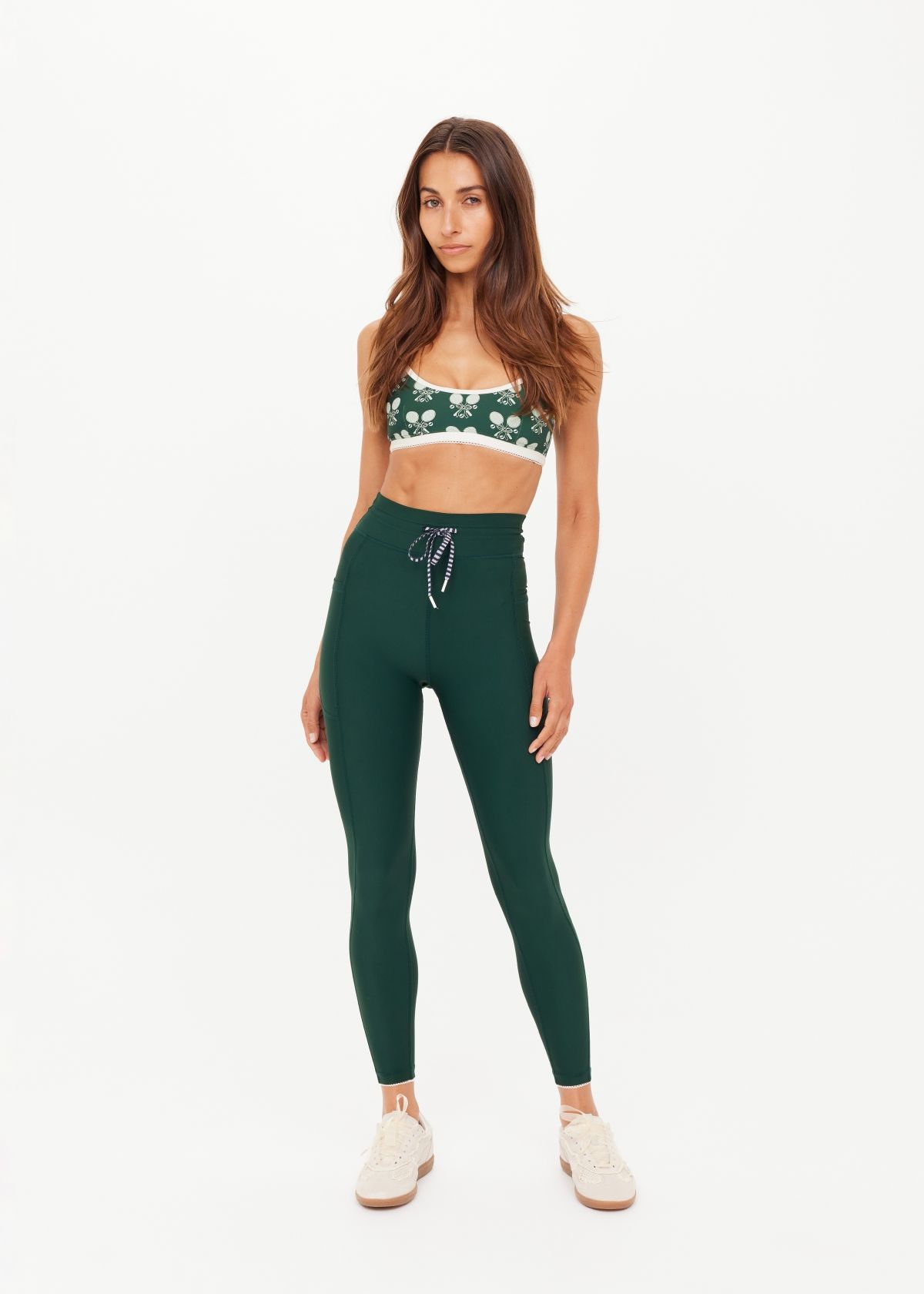 A woman in workout attire poses against a plain background.
