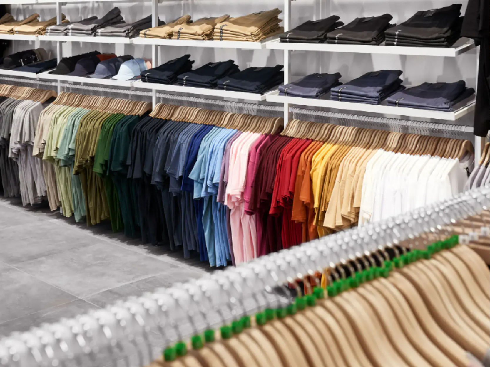 Clothes displayed on shelves and hangers in a retail store.