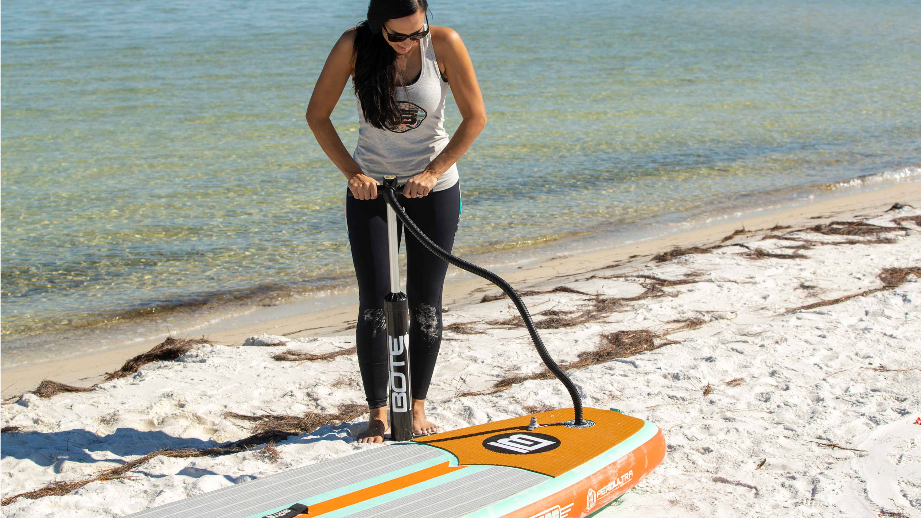 a girl inflating a BOTE inflatable paddle board