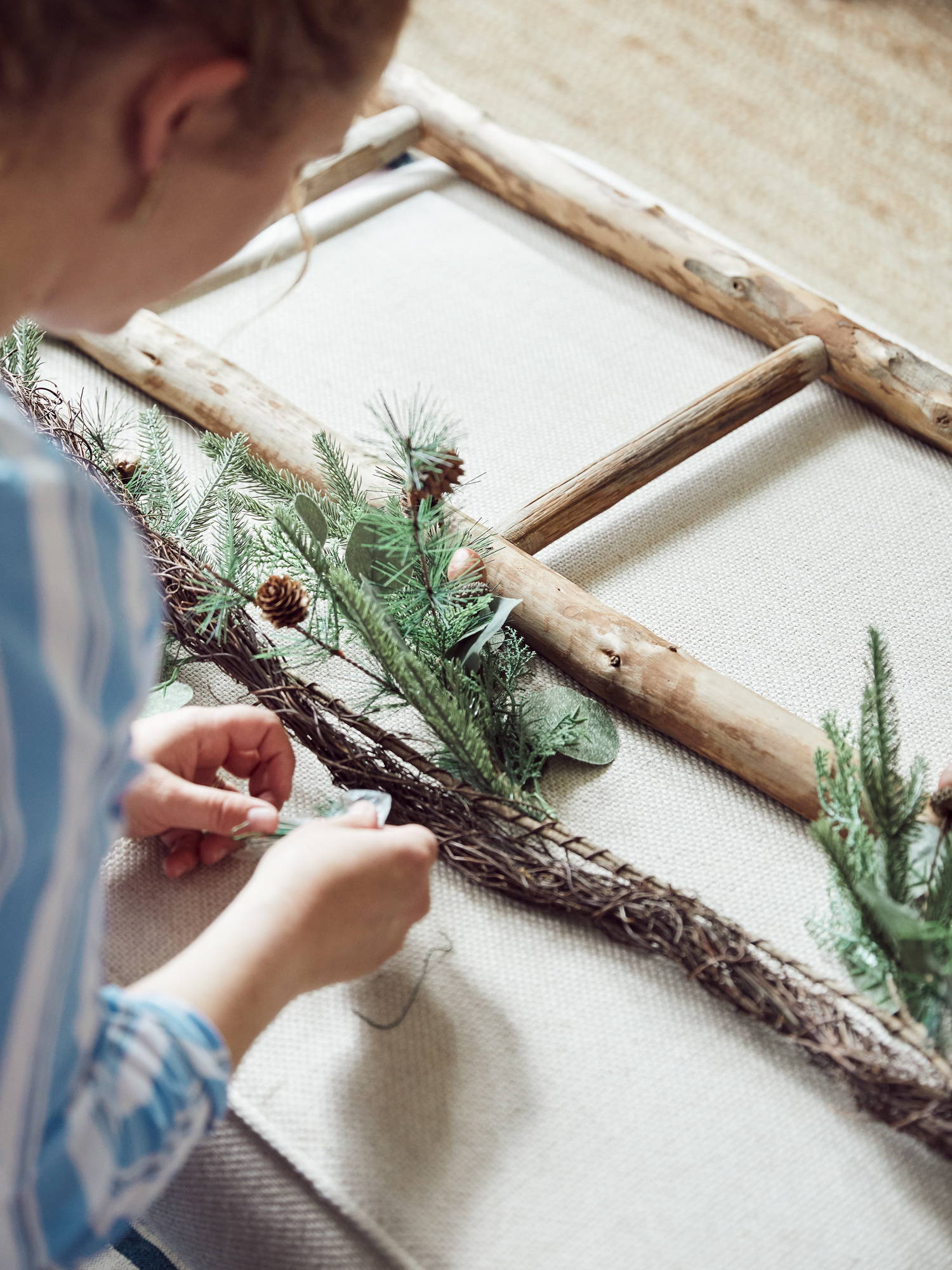 Person lining up the garland with the ladder