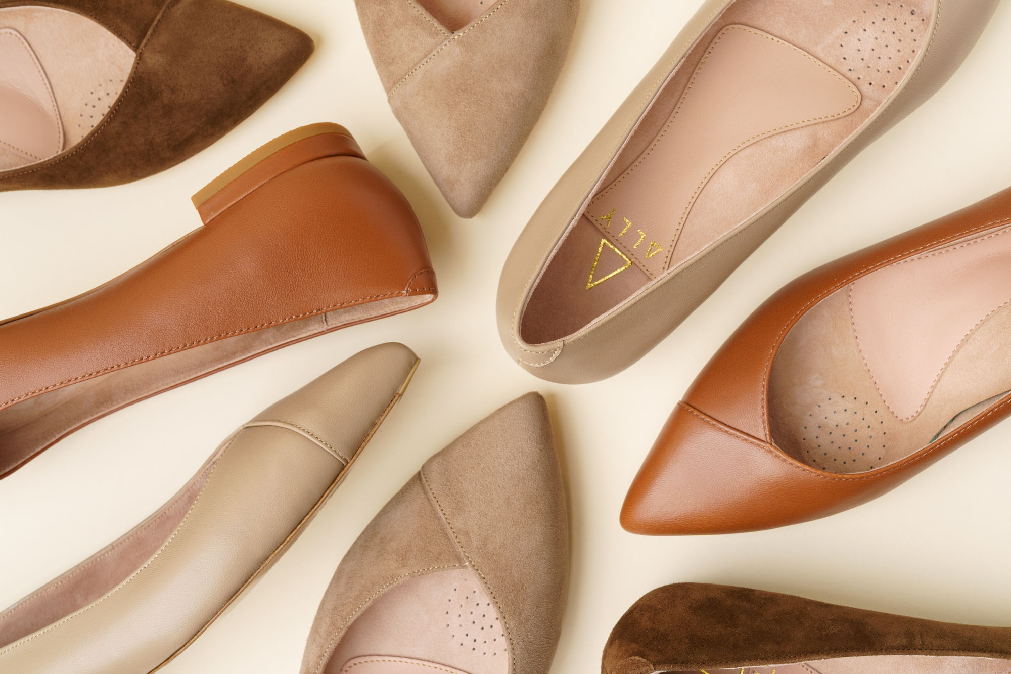 Various styles of women's shoes arranged on a light background.