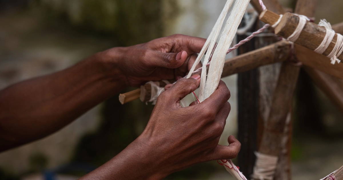 Man hand weaving a textile