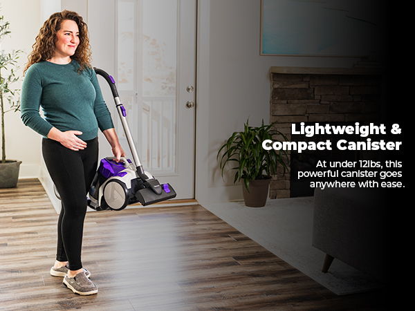 A woman holding a vacuum cleaner in a stylish living room.