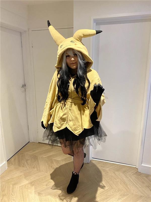 Person wearing a Pikachu costume with a black tutu and boots.