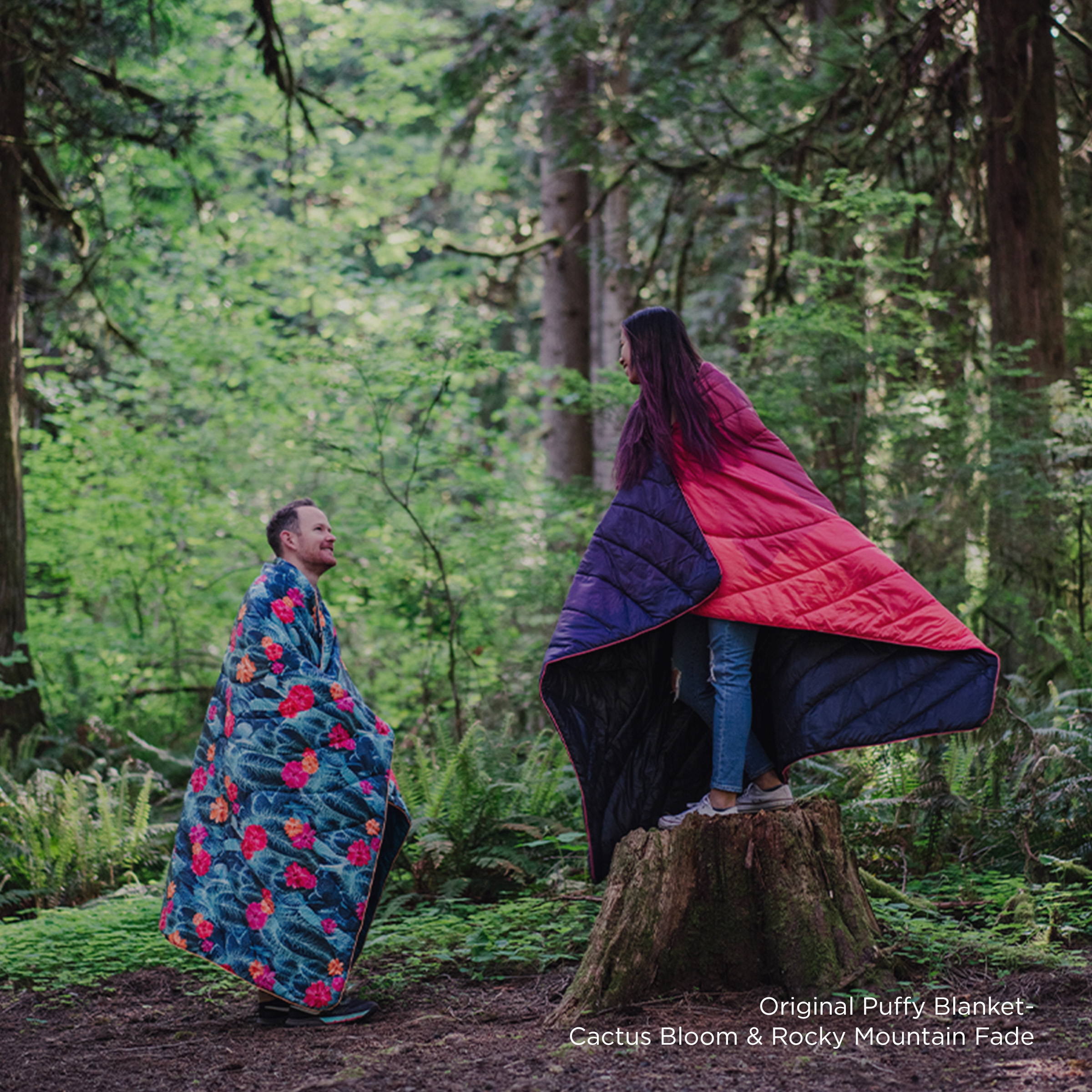 Two people wearing Rumpl blankets in nature