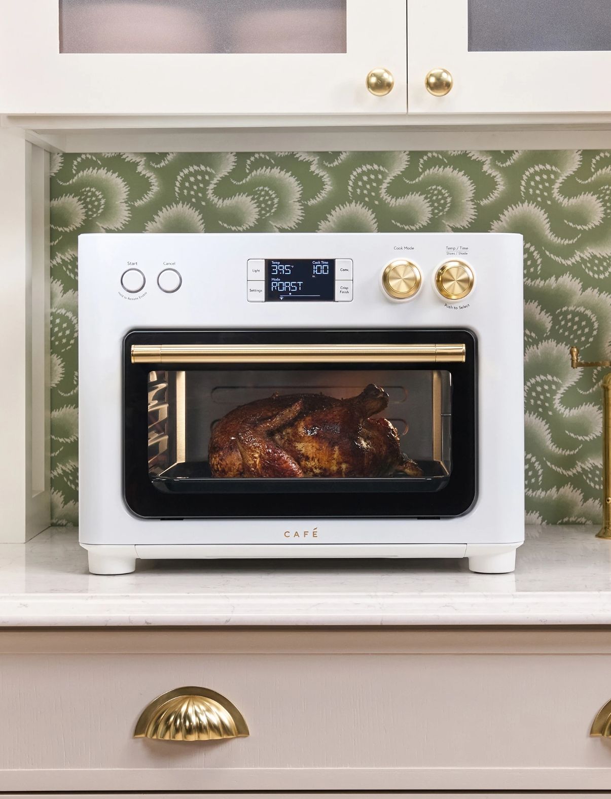 Modern countertop oven with a glass door, displaying a roasted dish inside.
