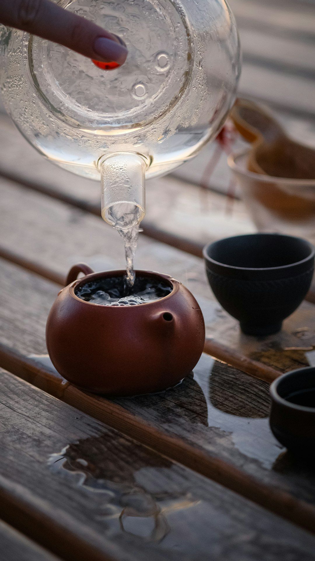 a hand pouring a liquid into a glass container