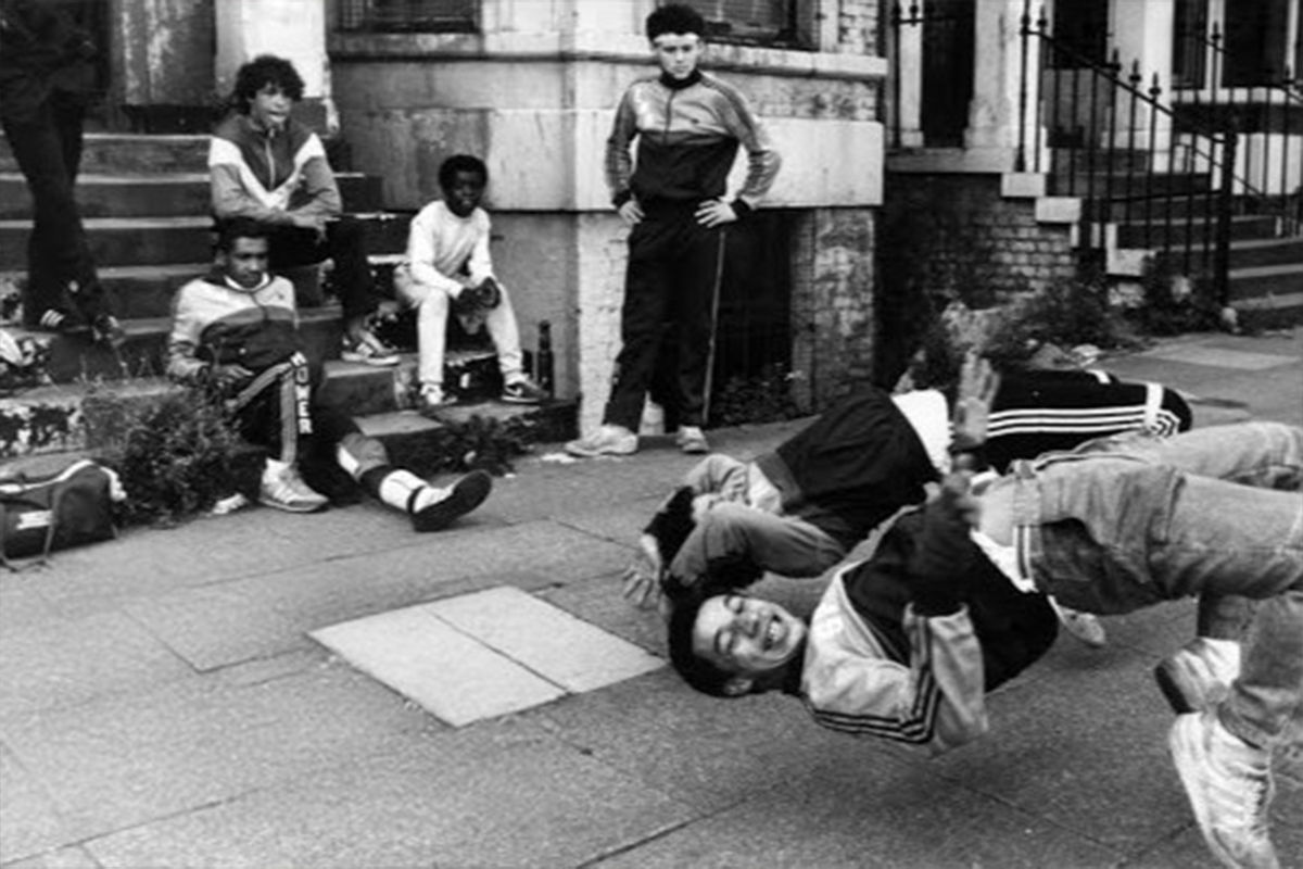 Group of people watching breakdancers on the street. Black and white photograph.