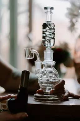 A man holding a glass dab rig