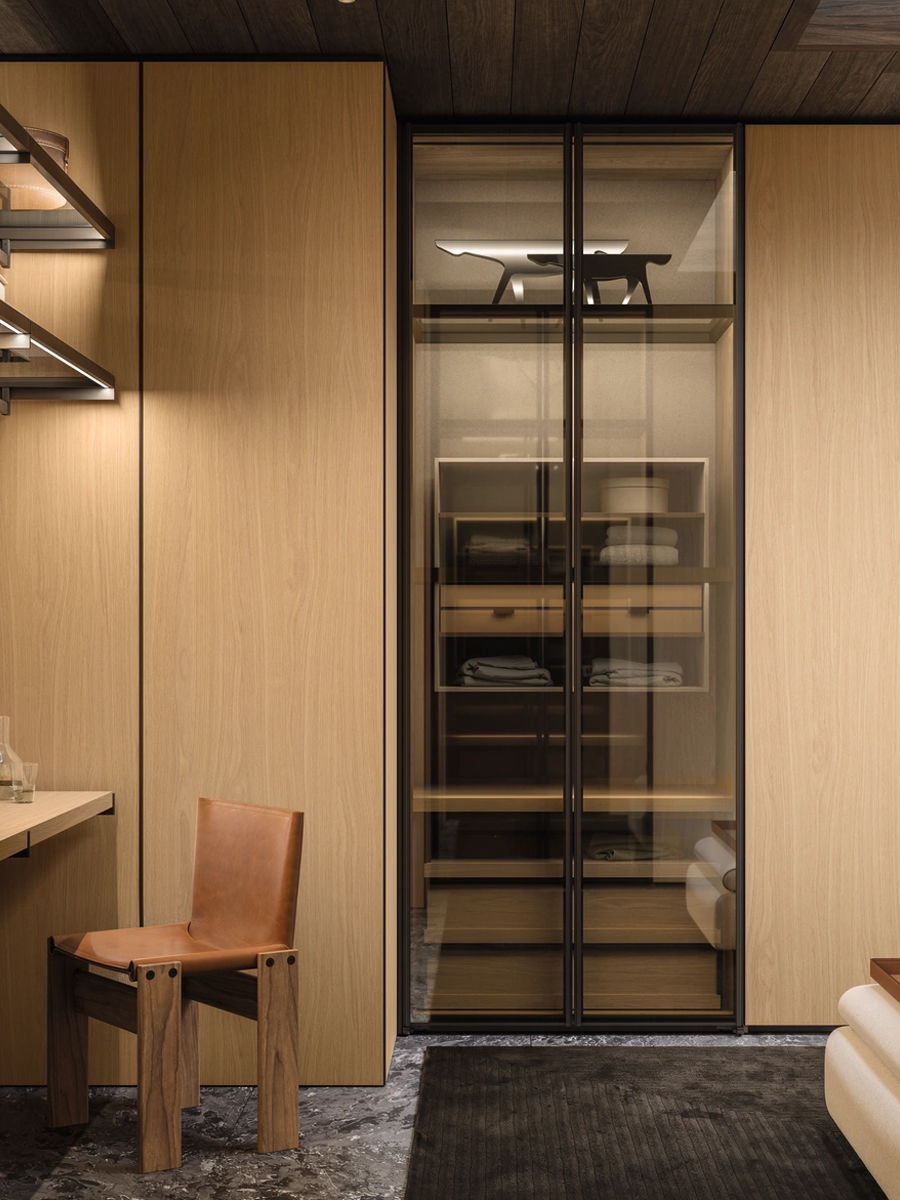 Modern Molteni wardrobe with clothing, accessories, and a stylish handbag on a table.