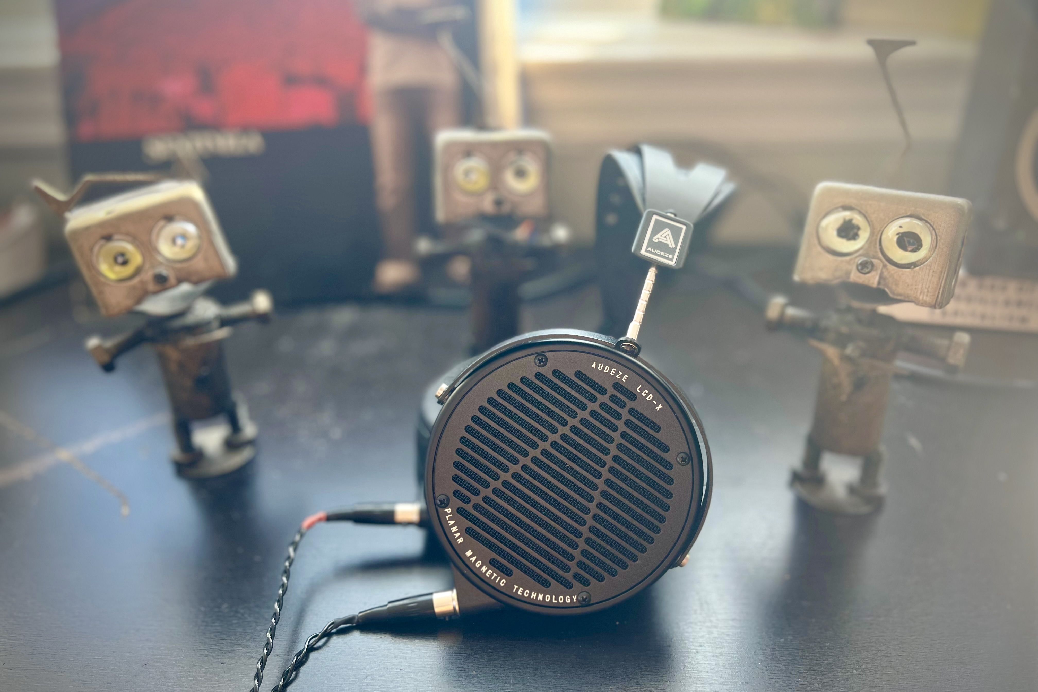 Audeze LCD-X headphones on table surrounded by handmade little robot figures