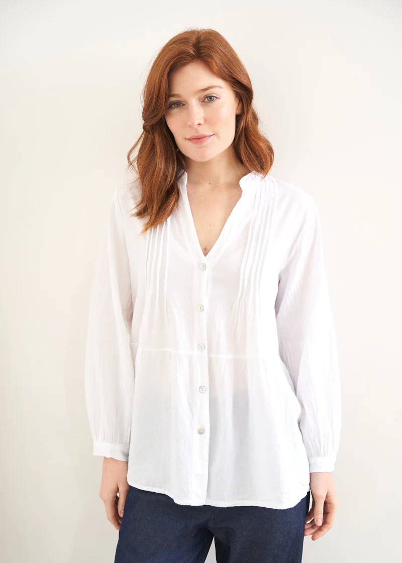 A model wearing a relaxed fitting cotton blouse with long sleeves, pin tuck detail and mother of pearl button down detail