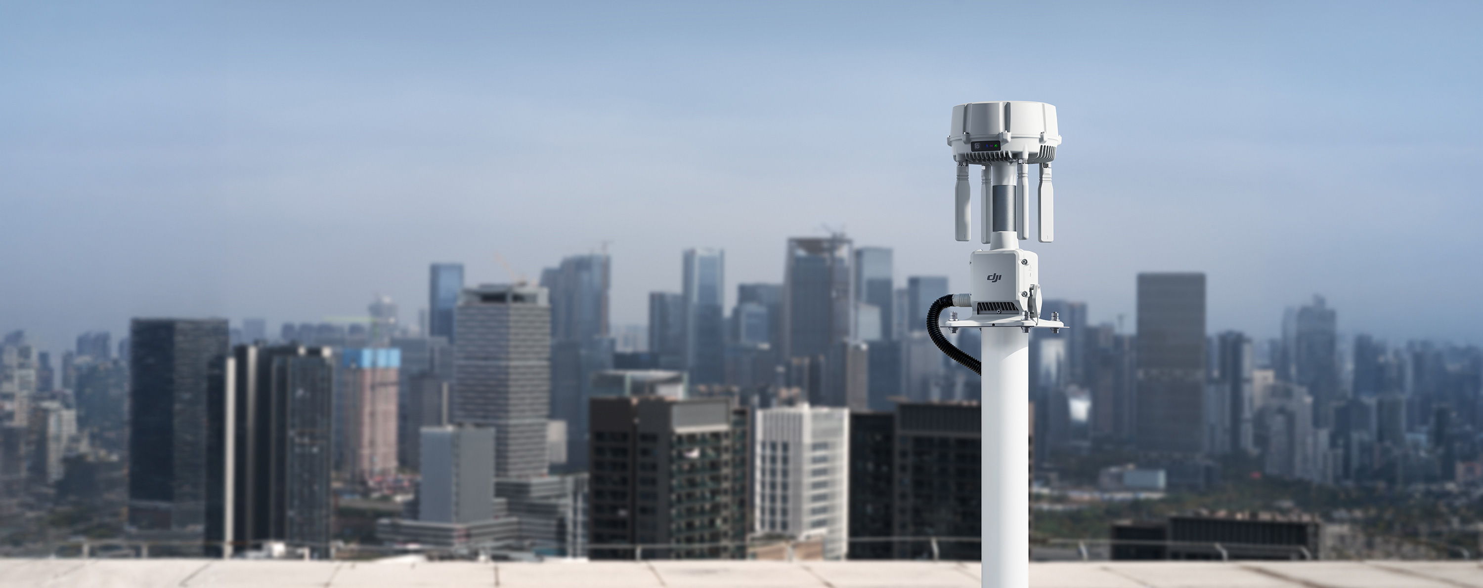 A rooftop view of a city skyline with a DJI O4 Ground Station in the foreground.