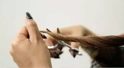 Woman cutting her split ends off her hair