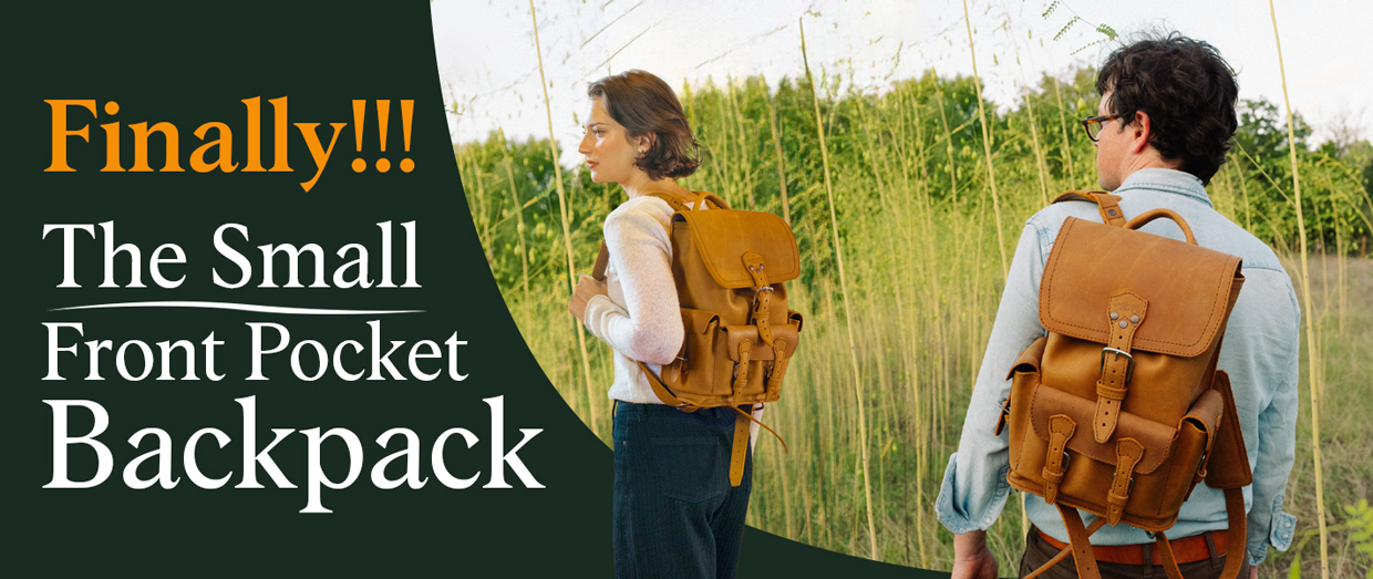 Two people wearing backpacks in a grassy outdoor setting.