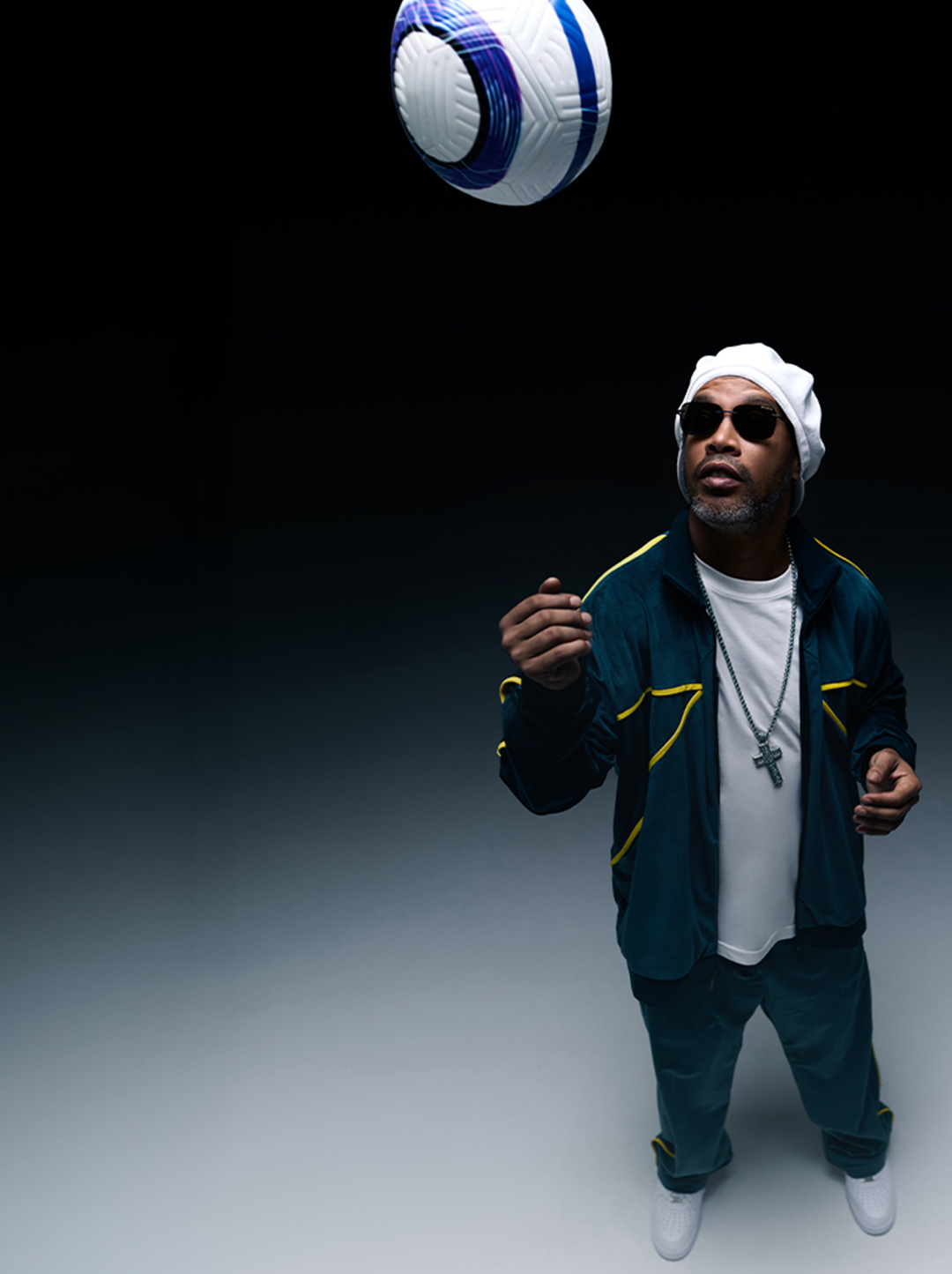 Ronaldinho in a tracksuit juggling a soccer ball.