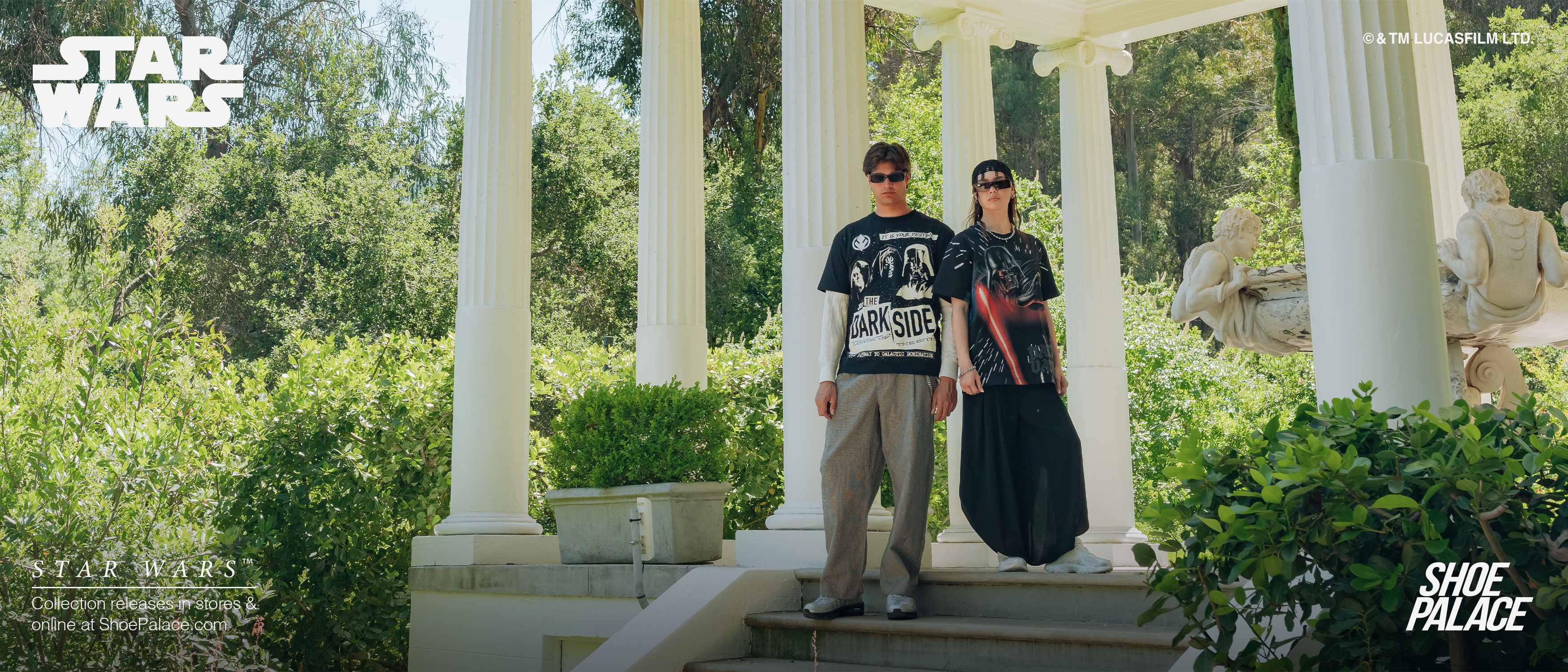 Two people in casual attire walking near a white columned structure.