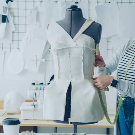Women working on a garment on a dress form