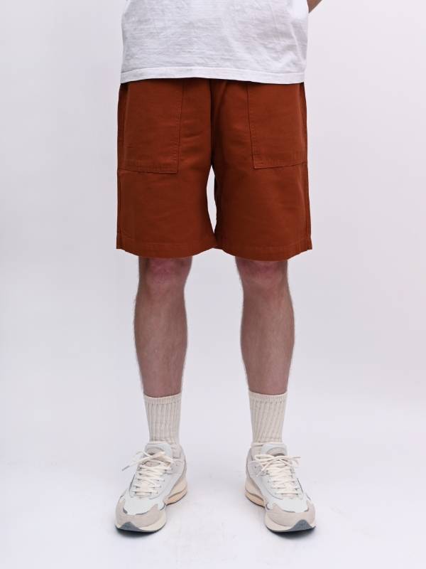 A model wearing Service Works Canvas Chef Shorts.