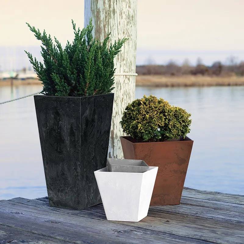 Various Artstone resin planters on a dock next to the water