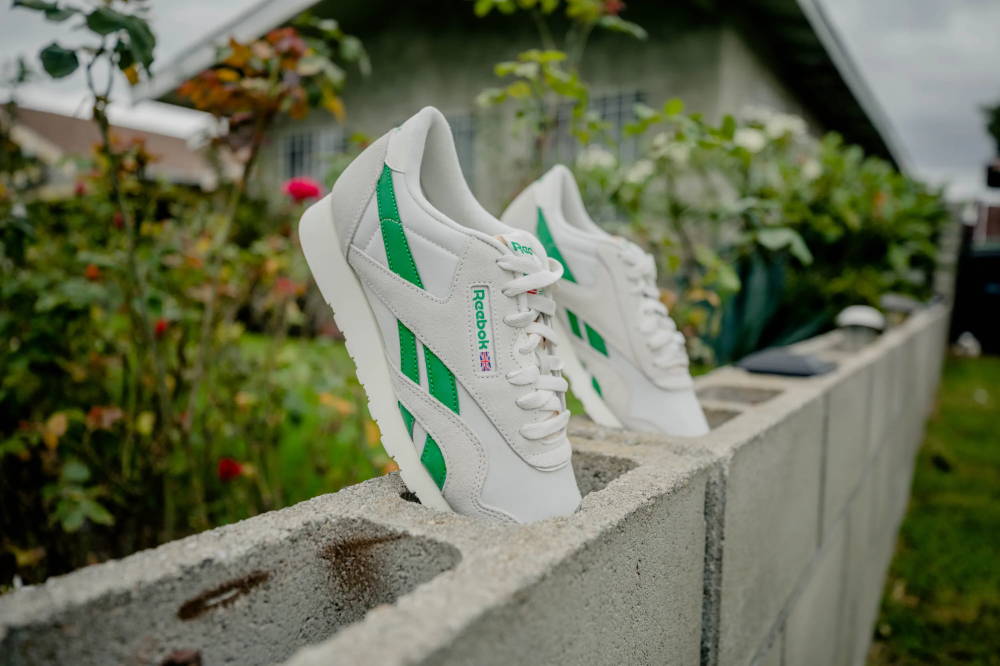 reebok grey and green sneakers on wall outside house