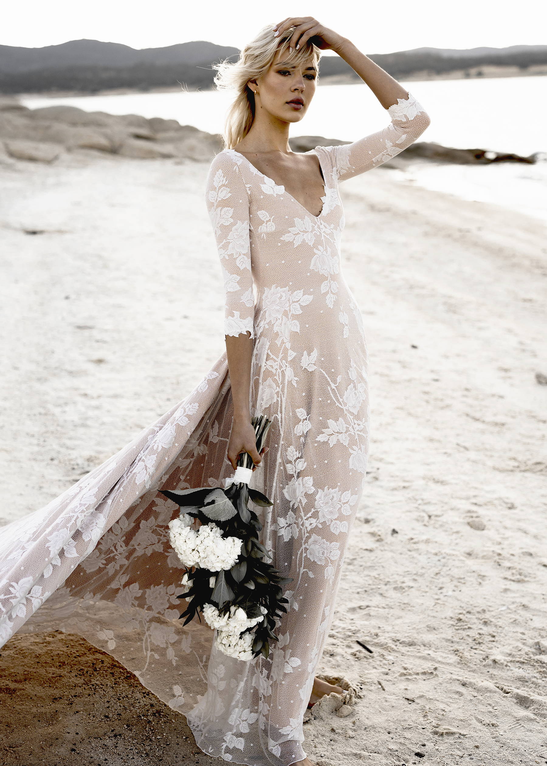woman wearing floral lace elopement dress on the beach