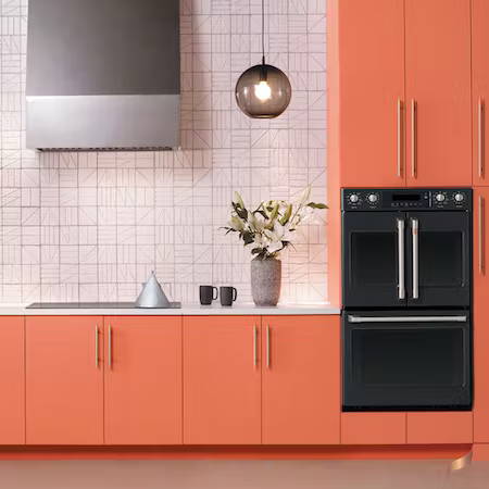Matte black double wall oven in kitchen with peach cabinets 