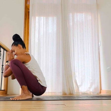 Chelsea in molasana yogi squat yoga pose.