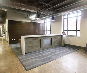 Modern office reception area with a large desk and natural light.