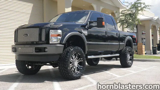 Wicked Customs's lifted black 2008 Ford F250 Super Duty with custom grille parked in a commercial lot