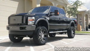 Wicked Customs's lifted black 2008 Ford F250 Super Duty with custom grille parked in a commercial lot