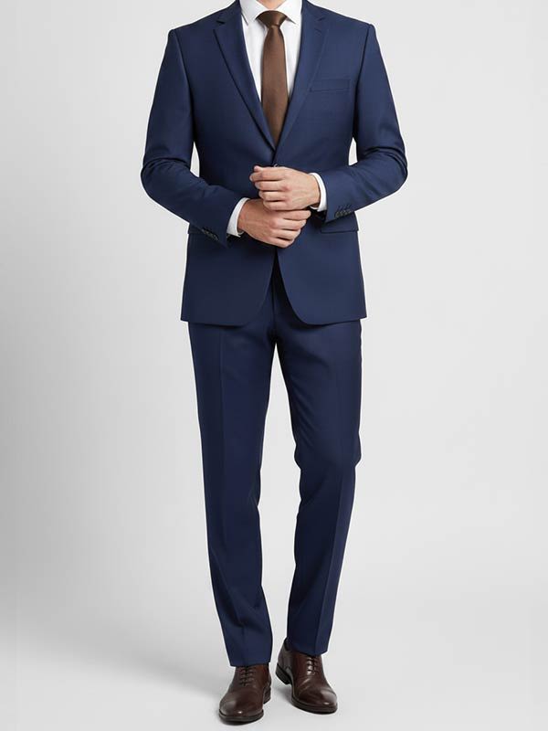 Man in business attire wearing a navy suit with a brown tie