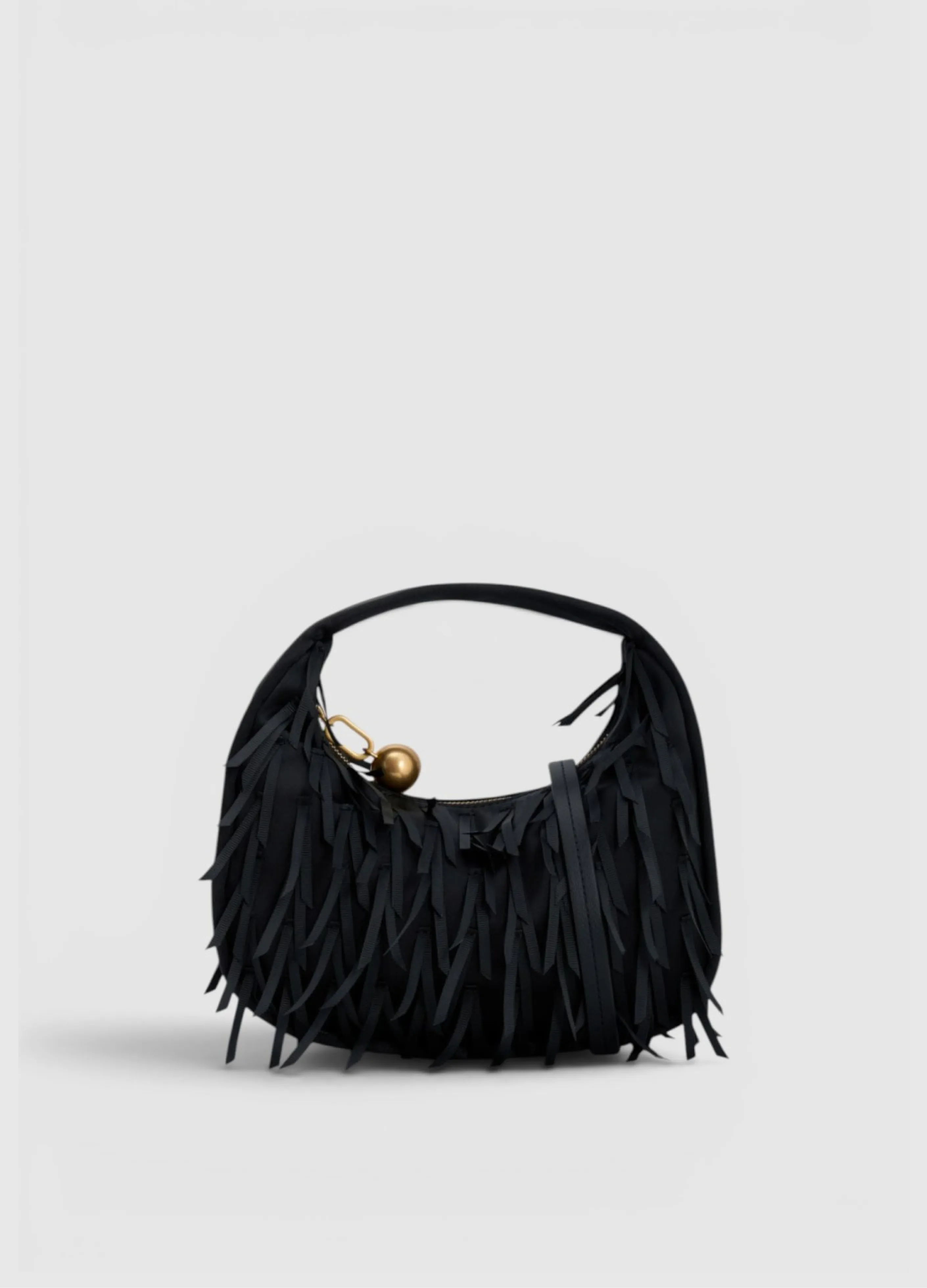 Black fringed handbag with a decorative gold ball charm.