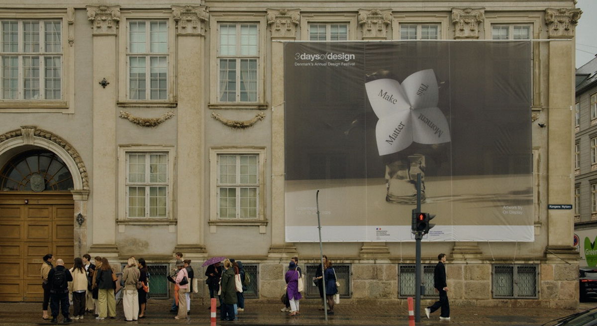 People standing in front of a building with a large advertisement.