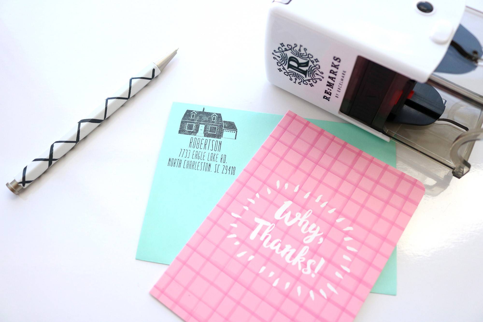 Self-Inking stamp sitting next to a thank you card