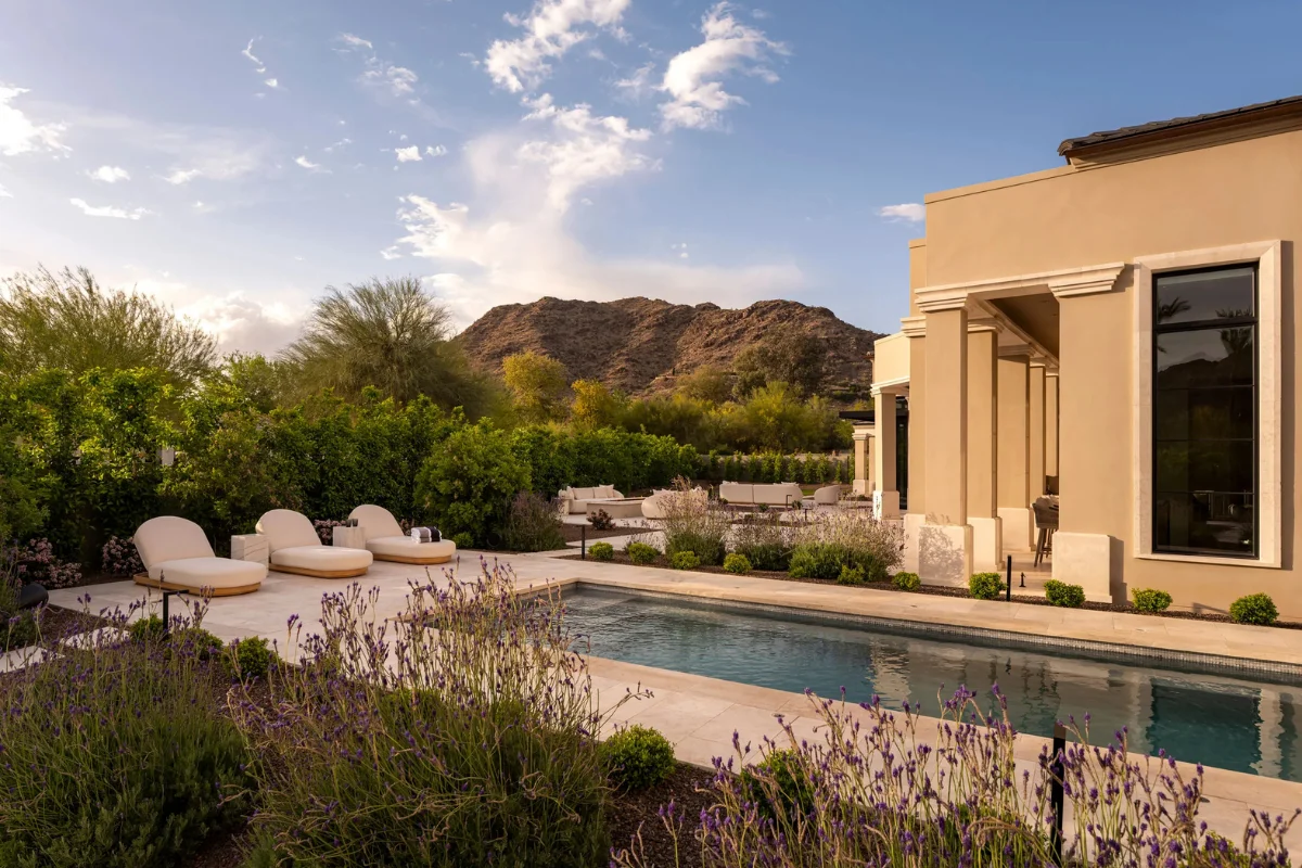 Elegant Arizona backyard pool surrounded by layered planting, lounge seating, and shade opportunities that help create a cooler and more usable outdoor living space.