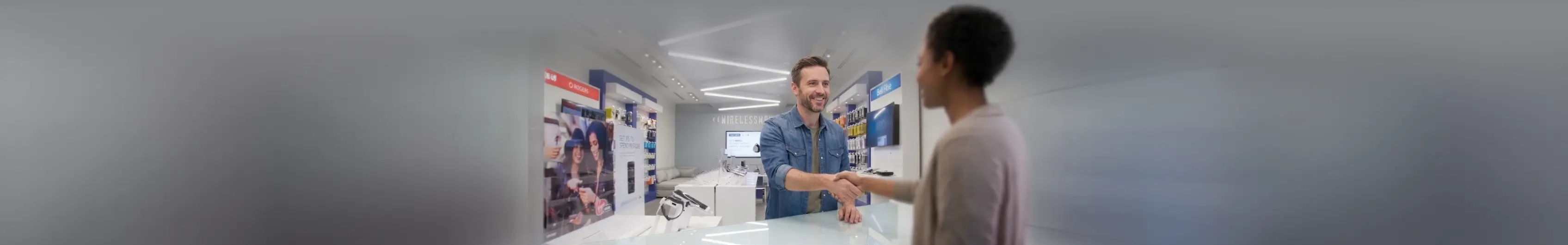 Two people discussing in a modern workspace with technology around them.