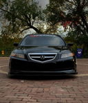 Front-facing low-angle view of Adonis's black 2005 Acura TL with Taramps Amplificadores windshield banner parked on brick pavers photo 1