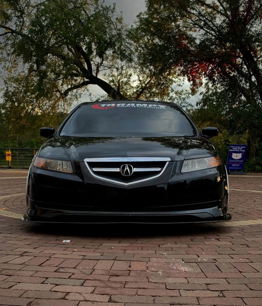 Front-facing low-angle view of Adonis's black 2005 Acura TL with Taramps Amplificadores windshield banner parked on brick pavers photo 1