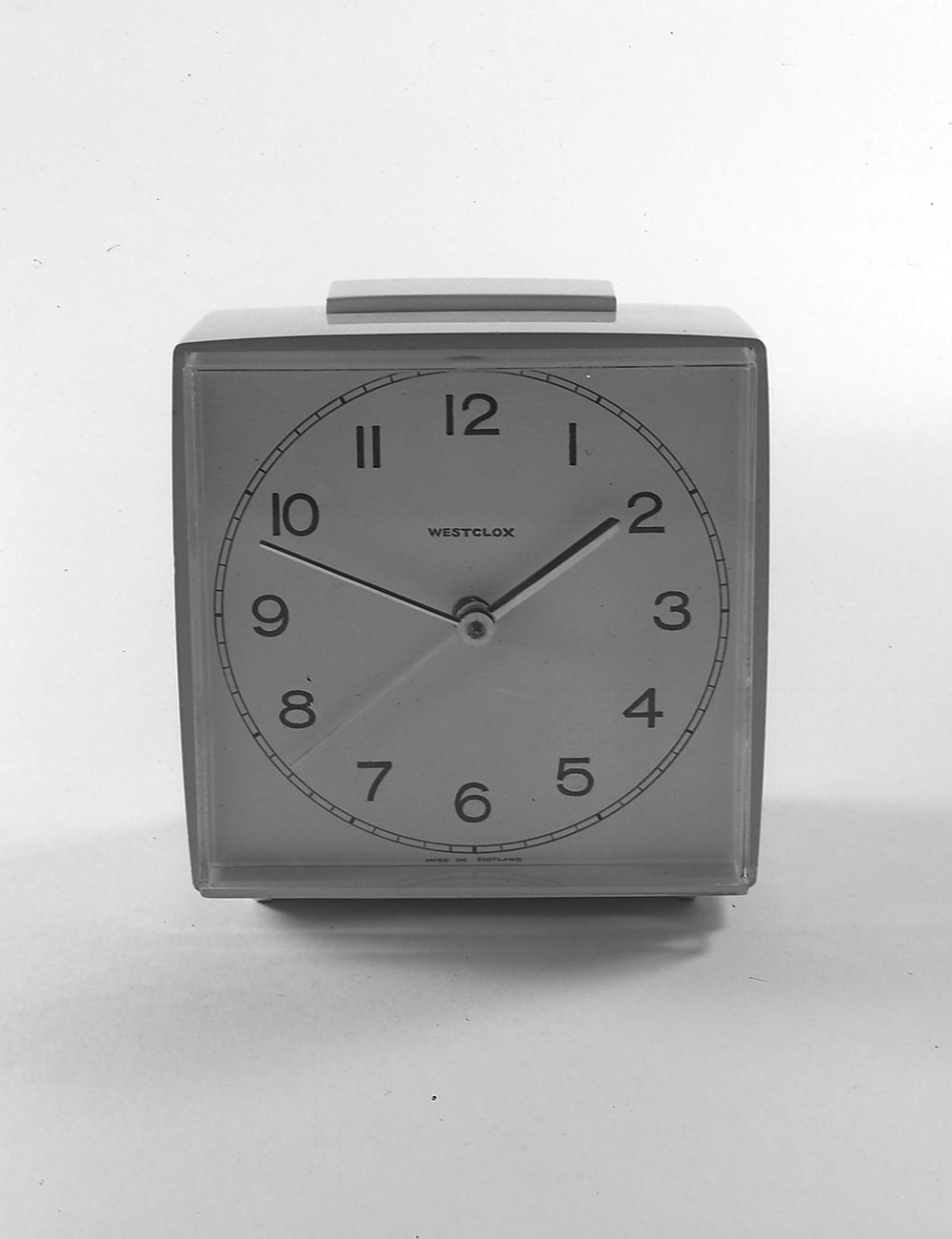 A square clock with black numbers on a white background.