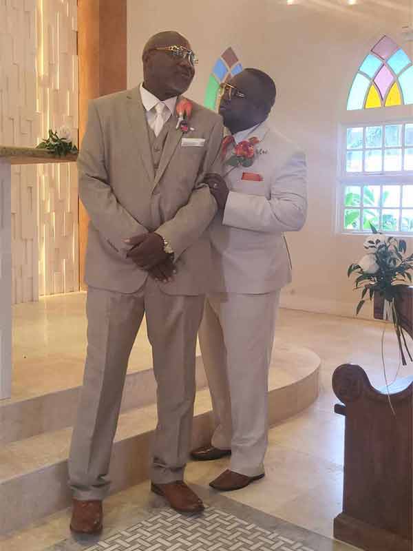 A groomsmen wearing a tan suit with an ivory necktie and pocket square